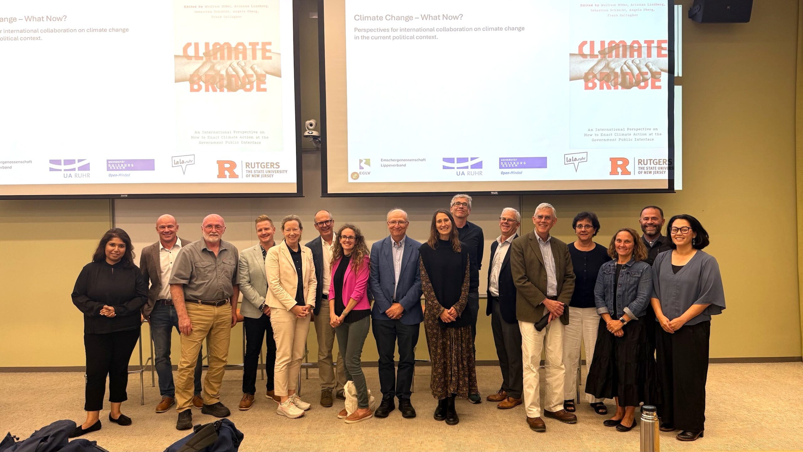 Authors and panelists standing in front of a screen with the text "Climate Bridge"